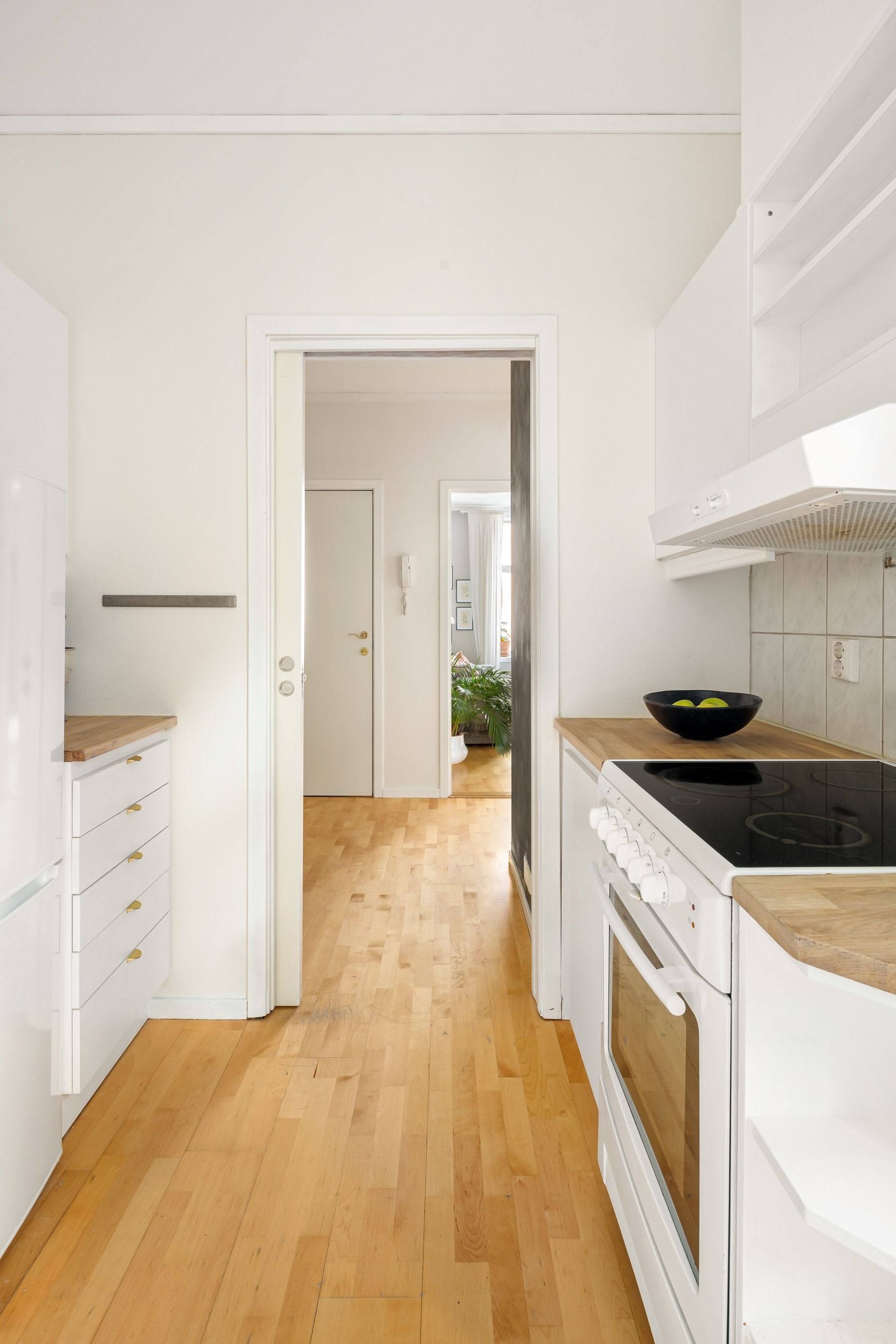 A bright, tidy kitchen with clear counters and warm wood floors